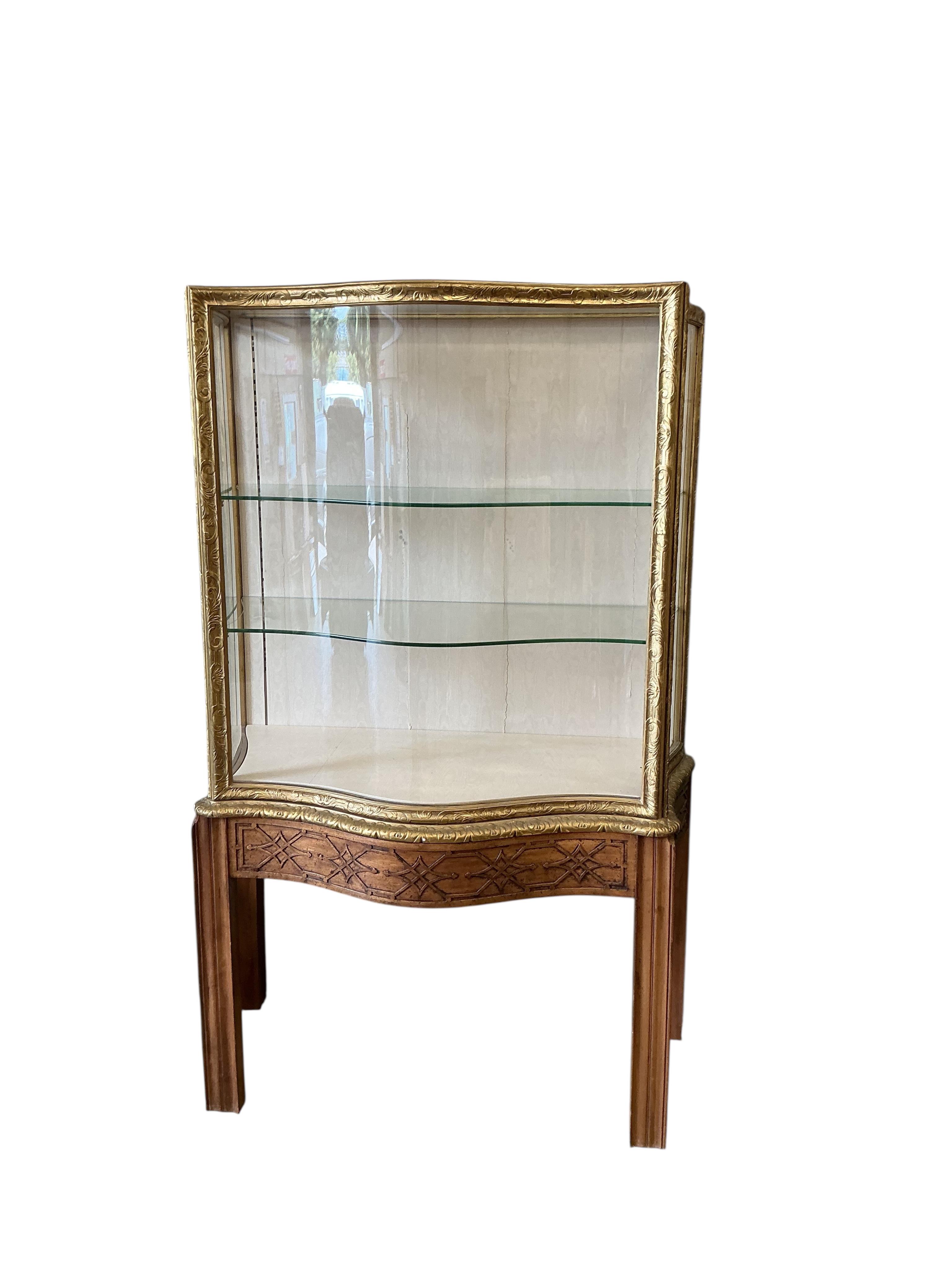 A George III style mahogany and giltwood serpentine display cabinet on blind fret stand, width 106cm, depth 60cm, height 181cm